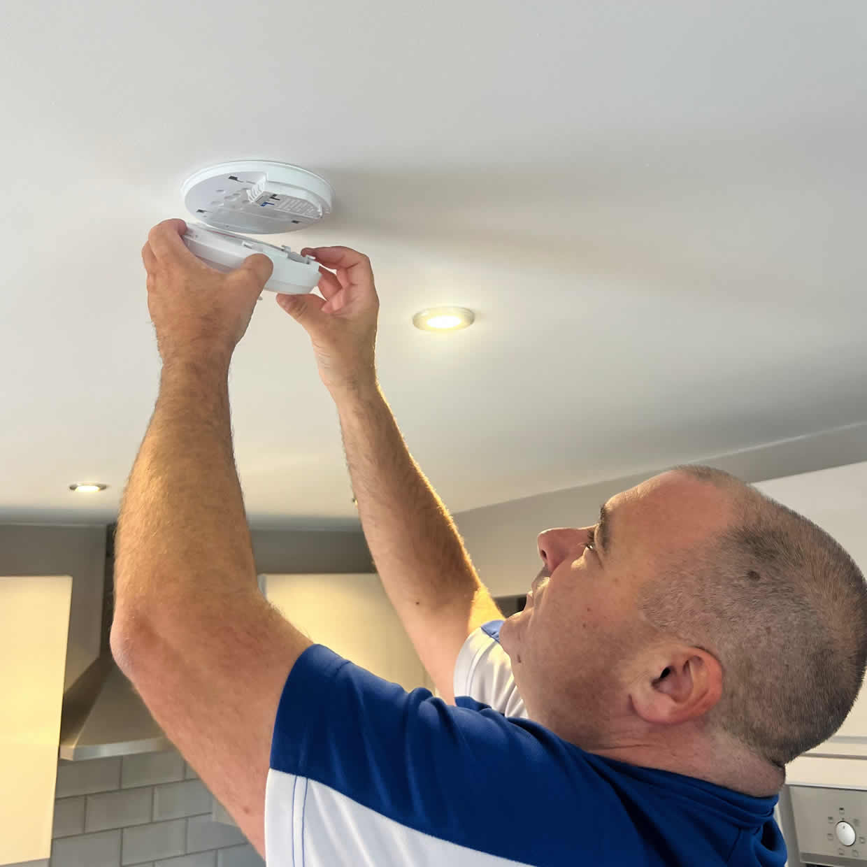 Smoke alarm being installed on a ceiling in Ashford